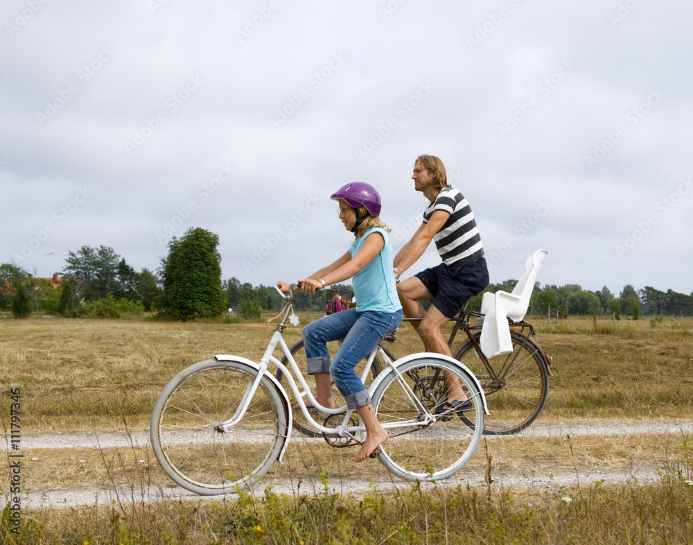 Father and daughter on a bicycle excursion. Father and daughter on a bicycle excursion.