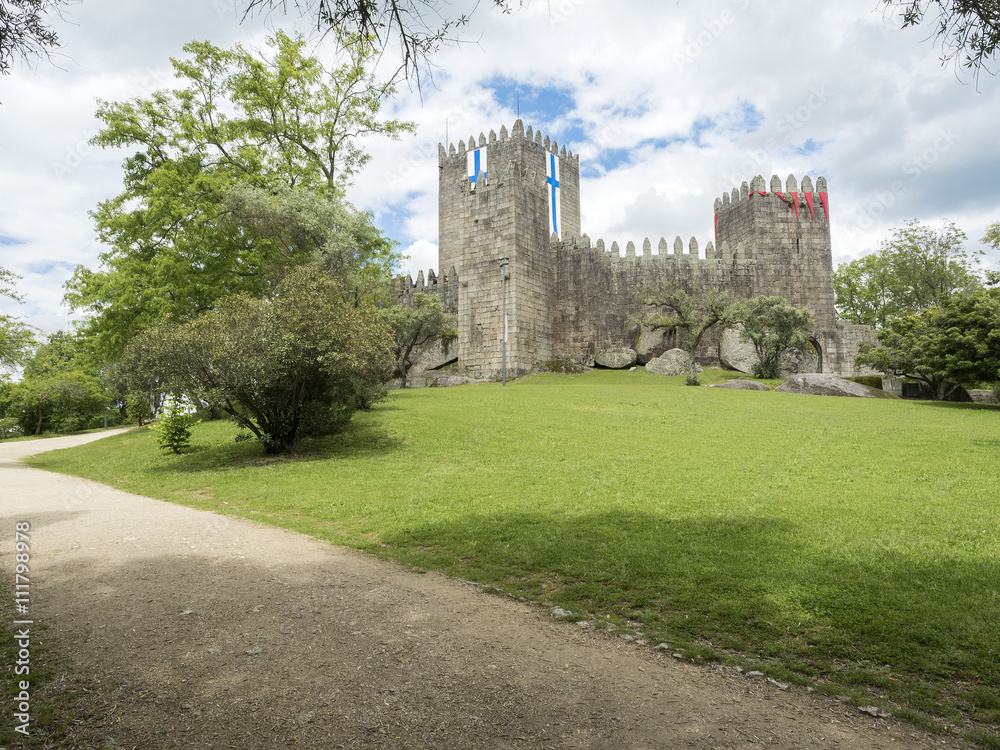 Naklejka premium Guimaraes castle with the flag of the city, north of Portugal