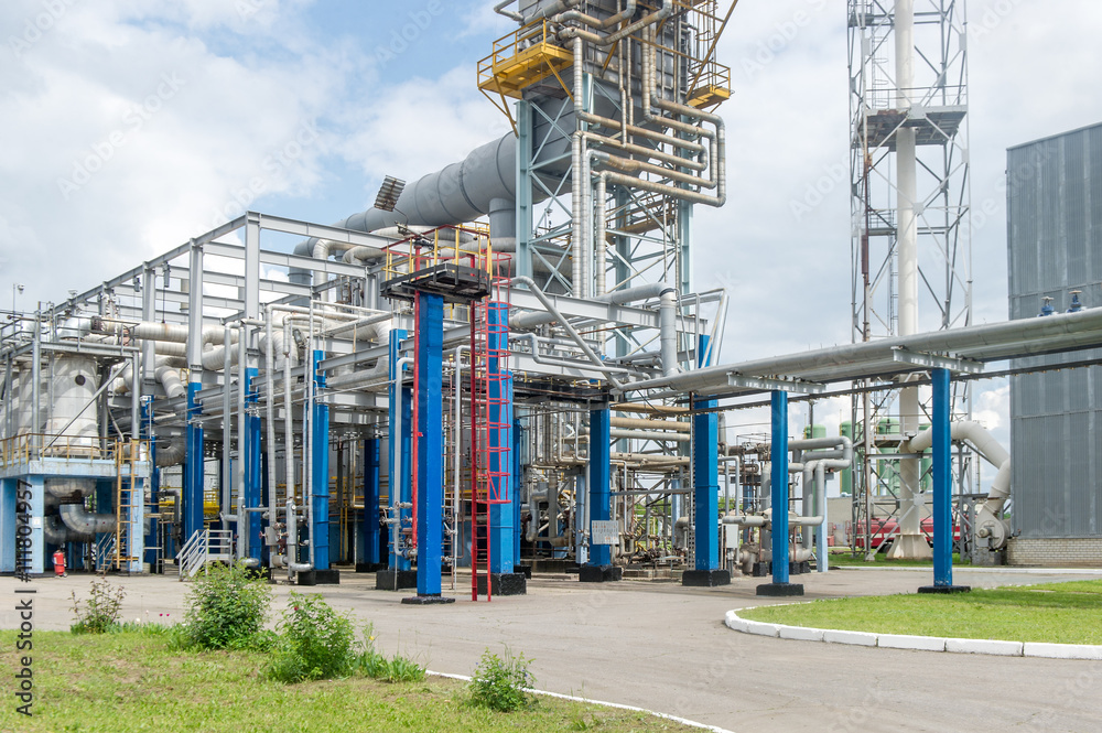 Industrial equipment and pipelines at the gas processing plant on a summer day Industrial equipment and pipelines at the gas processing plant on a summer day