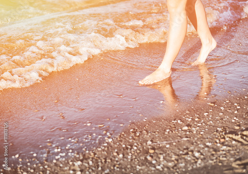 Woman walking on sandy beach in summer sun, enjoying vacation