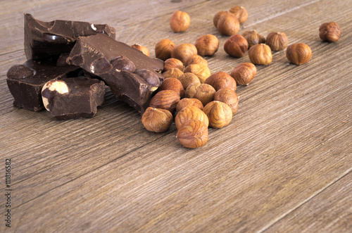 Pezzi di cioccolata fondente con nocciole su tavolo rustico. Primo piano photo