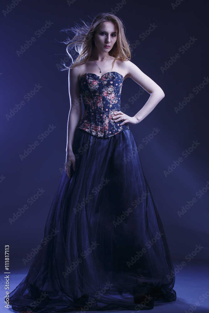 Portrait of a woman in a beautiful dress with a floral pattern in the Studio Portrait of a woman in a beautiful dress with a floral pattern in the Studio