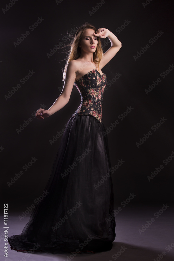 Portrait of a woman in a beautiful dress with a floral pattern in the Studio Portrait of a woman in a beautiful dress with a floral pattern in the Studio