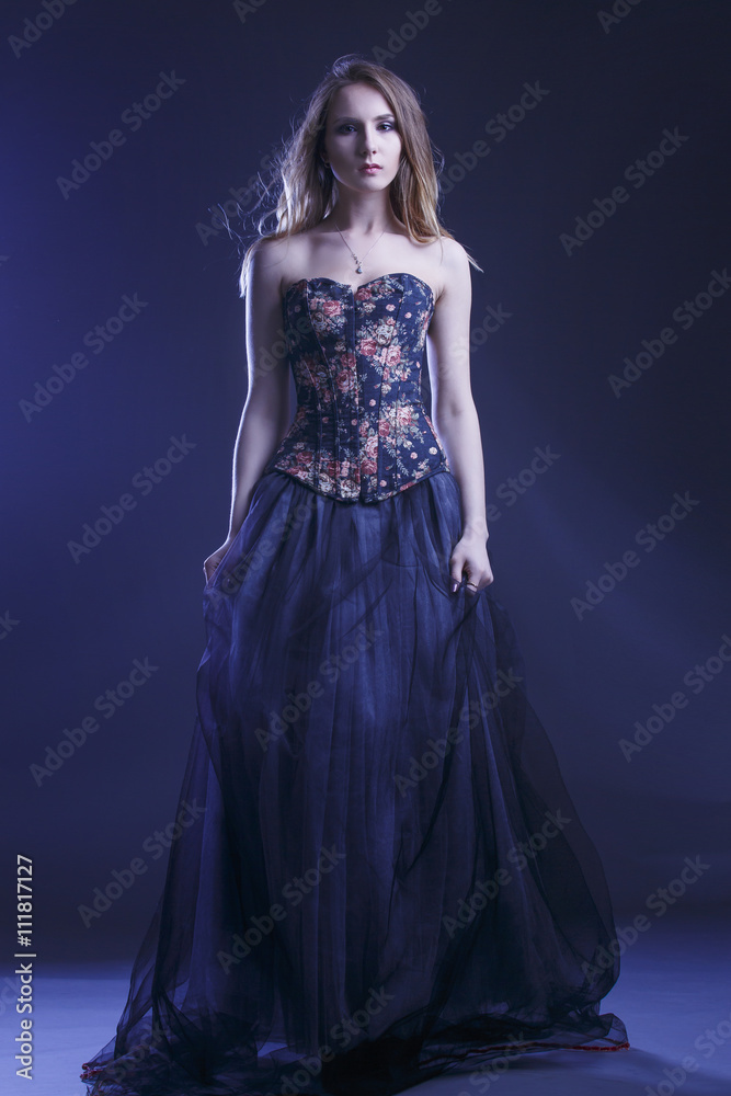 Portrait of a woman in a beautiful dress with a floral pattern in the Studio Portrait of a woman in a beautiful dress with a floral pattern in the Studio