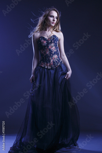Portrait of a woman in a beautiful dress with a floral pattern in the Studio