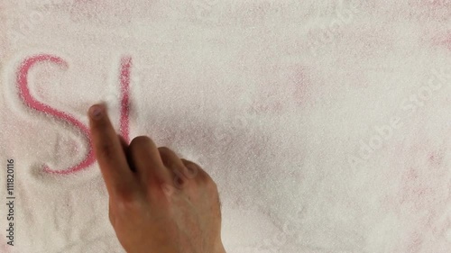 Men hand draws word stevia on the surface of sugar photo