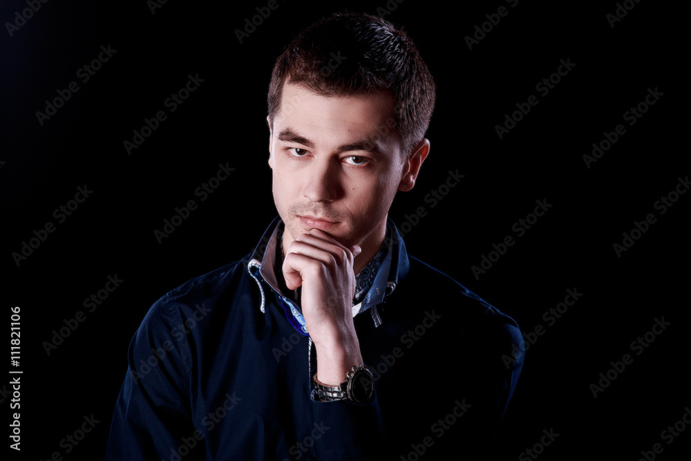 Portrait of handsome man in blue sweater on a dark background in the Studio Portrait of handsome man in blue sweater on a dark background in the Studio