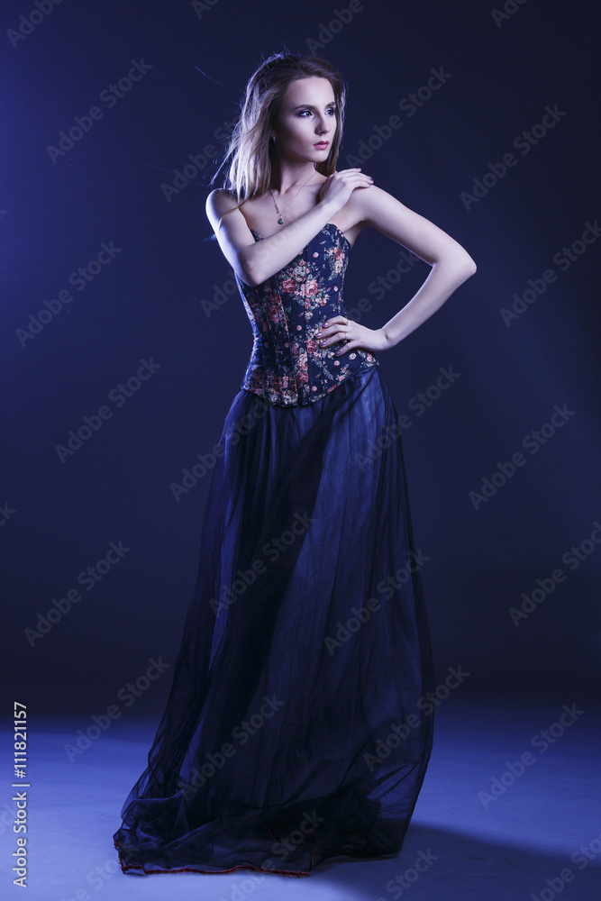 Portrait of a woman in a beautiful dress with a floral pattern in the Studio Portrait of a woman in a beautiful dress with a floral pattern in the Studio