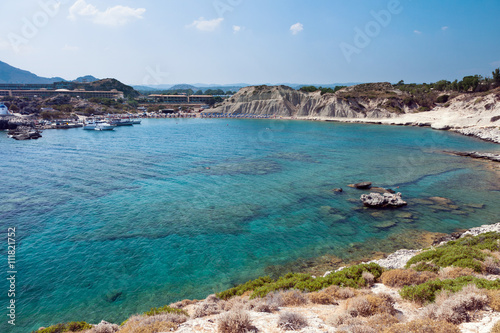 Kolymbia beach with boat and the rocky coast in Greece.