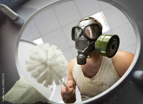 Fotografie Man cleaning the toilet bowl