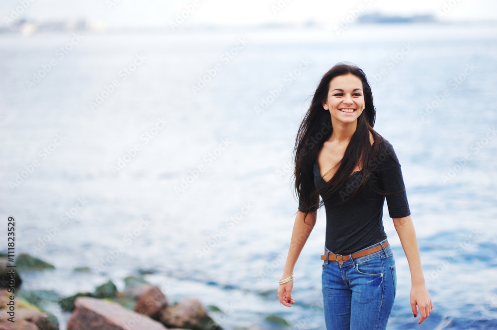 beautiful brunette girl standing on the embankment near the river beautiful brunette girl standing on the embankment near the river