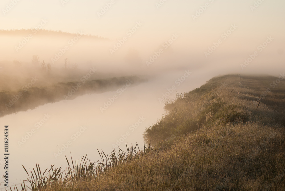 Mystical fog over the river at dawn