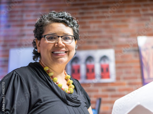 Happy And Confident Hispanic Woman In Office Environment