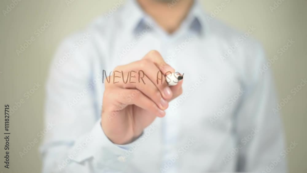 Never Assume Anything , man writing on transparent screen Never Assume Anything , man writing on transparent screen