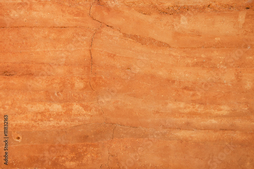Rammed earth wall with different shades of orange soil