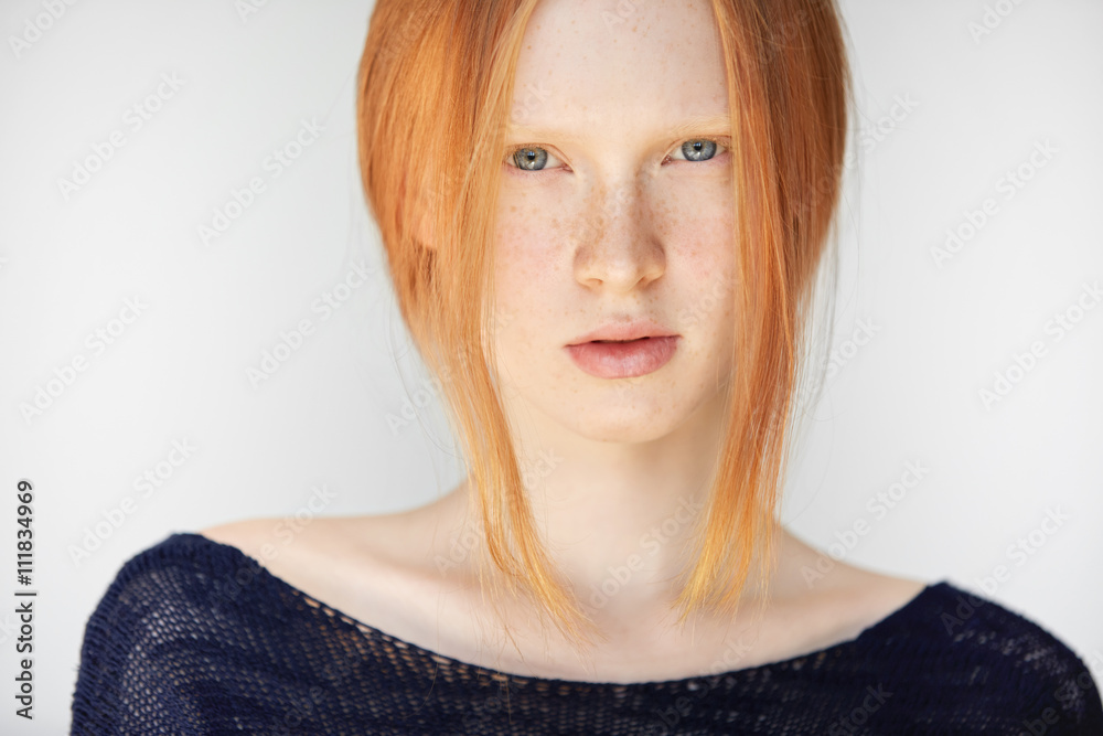Headshot of teenage girl with red hair, blue eyes and smooth fresh clean  skin, looking at