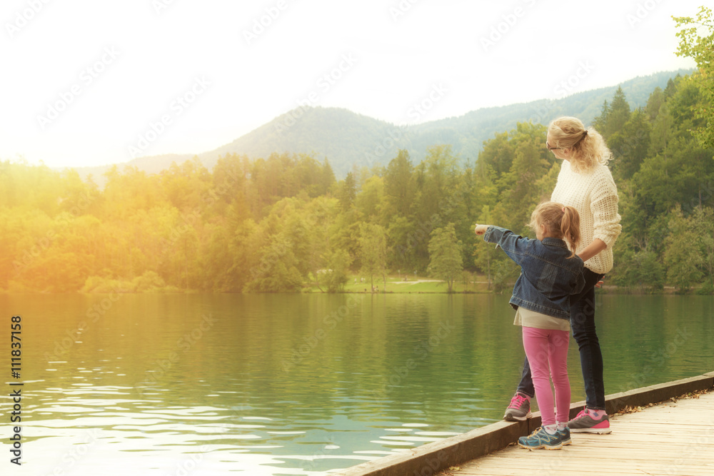 Mother and daughter enjoying the view on a lake.