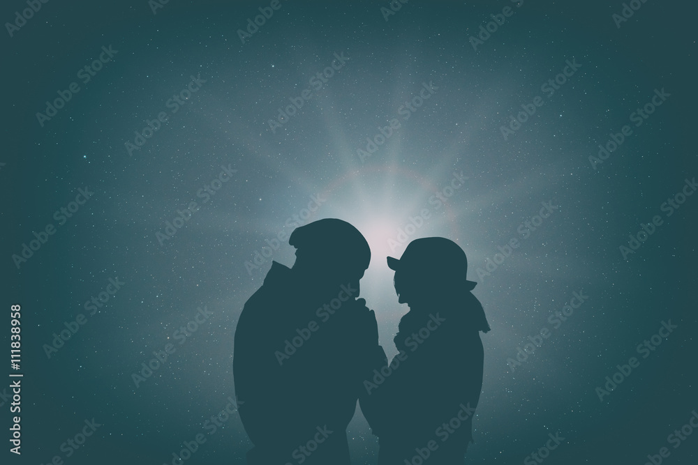 Silhouettes of a couple with starry and lunar background. 