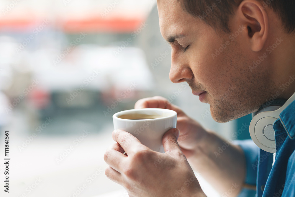 Attractive guy is enjoying hot beverage Attractive guy is enjoying hot beverage