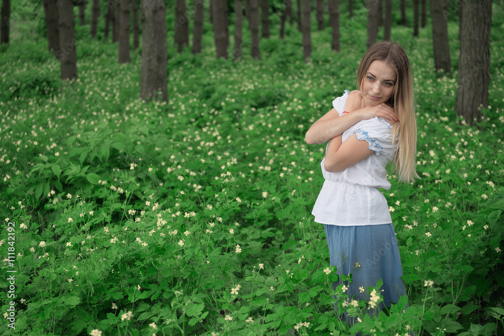 Beautiful young girl close-up in a white shirt, against a background of green forest Beautiful young girl close-up in a white shirt, against a background of green forest