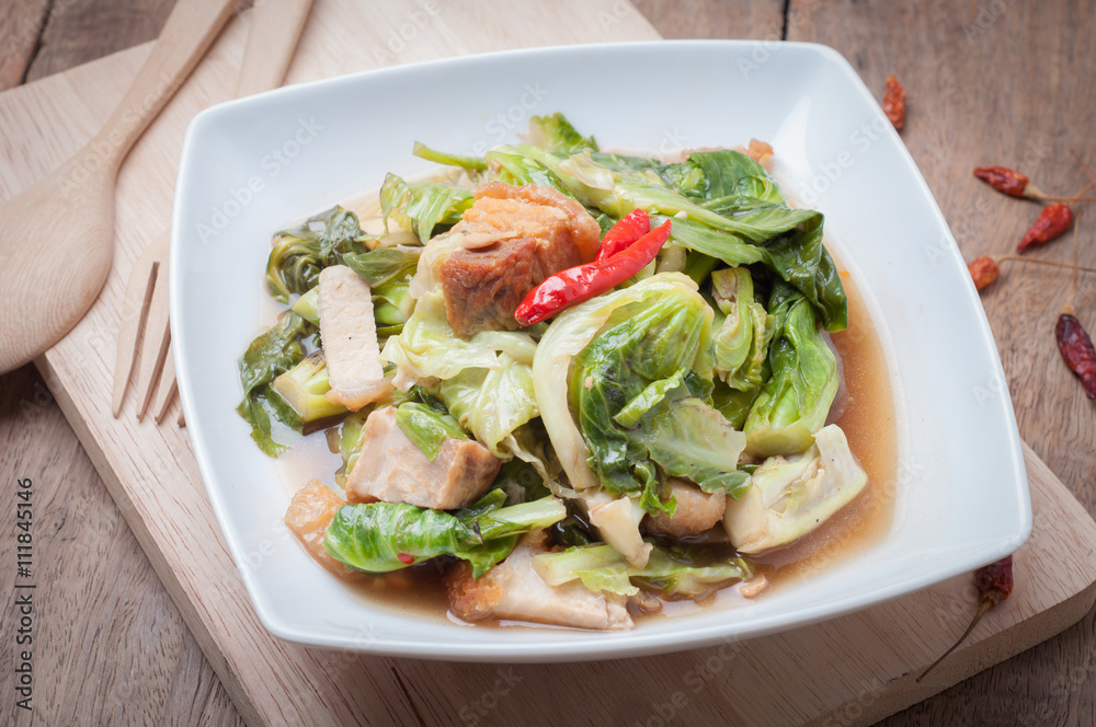 Fried Oyster sauce vegetables sect with crispy pork on wood floo Fried Oyster sauce vegetables sect with crispy pork on wood floo