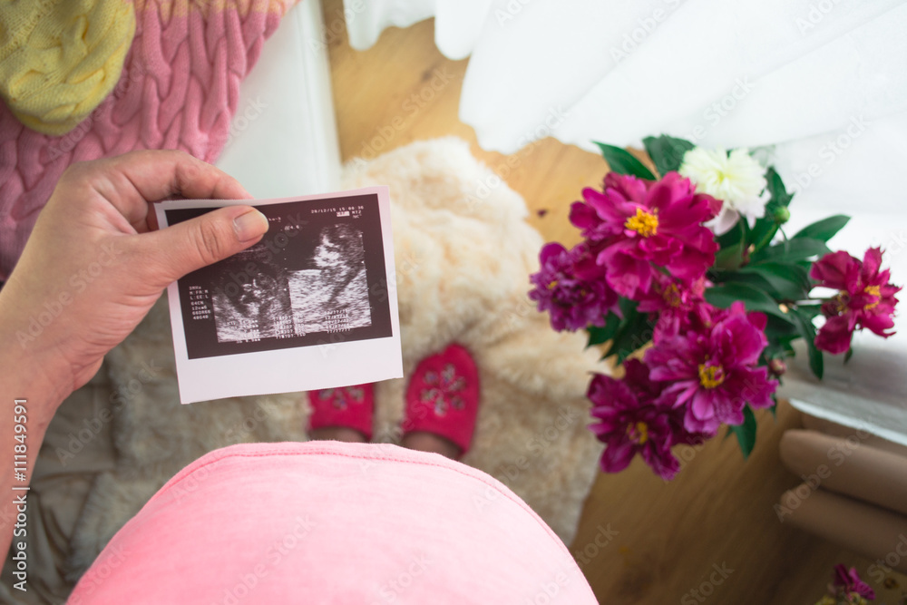 Pregnant Woman Looking At X-ray In Bedroom with Peonies Pregnant Woman Looking At X-ray In Bedroom with Peonies
