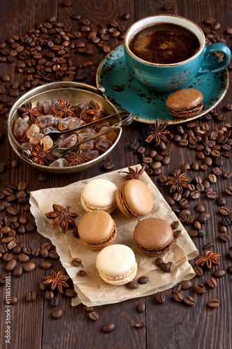 Delicious french macaroons on kraft paper with coffee on wooden table