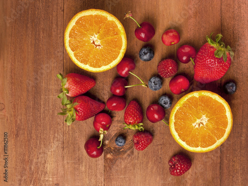 Fototapeta Naklejka Na Ścianę i Meble -  Bright oranges, strawberries, raspberries, blueberries and cherries