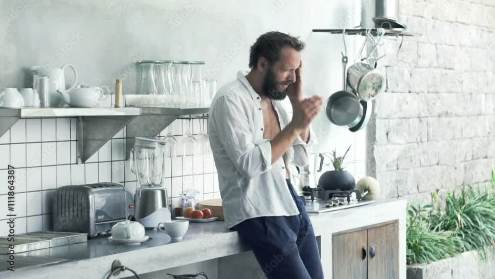 Young man having headache in kitchen at home
Young man having headache in kitchen at home