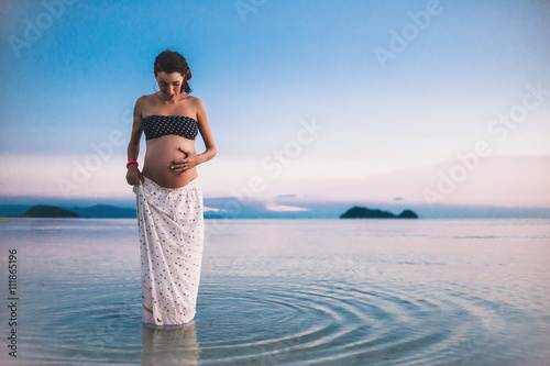 Obraz na płótnie Young happy pregnant woman at the beach at sunset w salonie