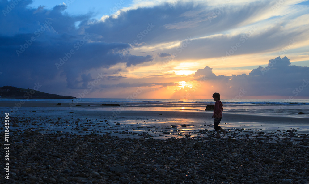 boy walking on the sandy beach on sunset
boy walking on the sandy beach on sunset