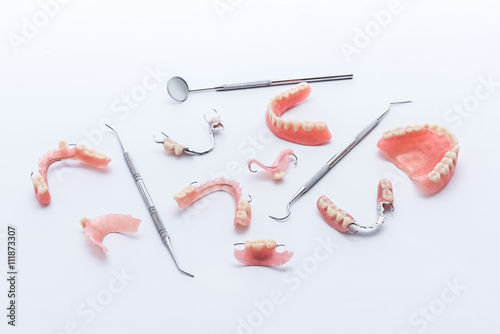 Set of dentures and dental tools on white background