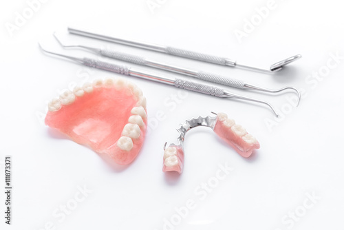 Denture and dental tools,dental mirror on white background