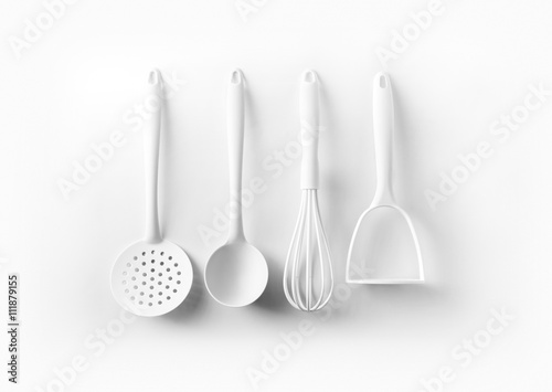 White kitchen tools hanging on white background