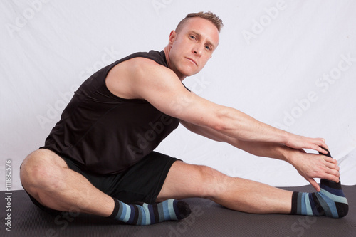 Man sitting on the floor and stretching