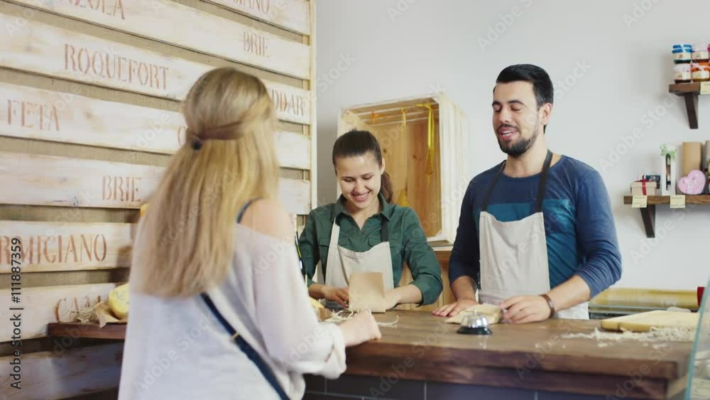Shopping in the store cheese. Behind the counter working man and woman friendly smile. Shopping in the store cheese. Behind the counter working man and woman friendly smile.