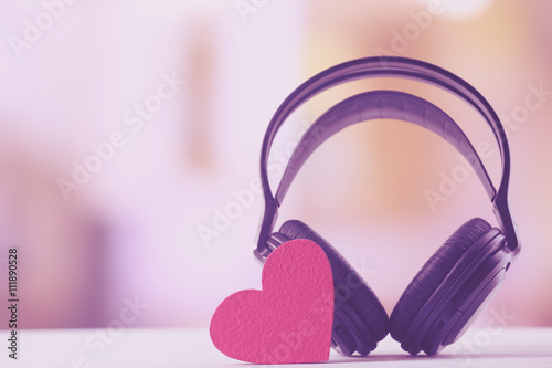 Black headphones with heart on unfocused background