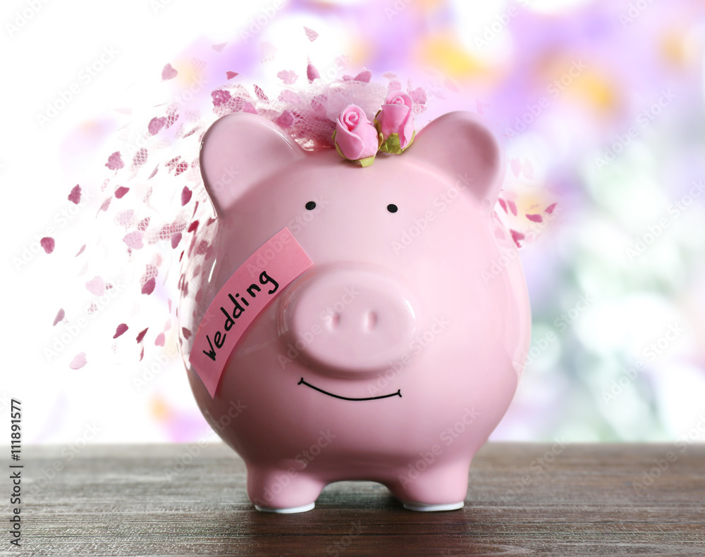 Piggy bank with wedding veil blurred festive background