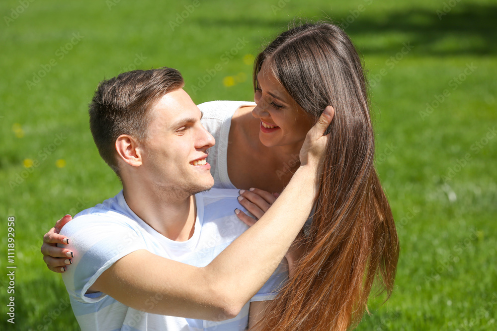 Young loving couple on green grass background Young loving couple on green grass background
