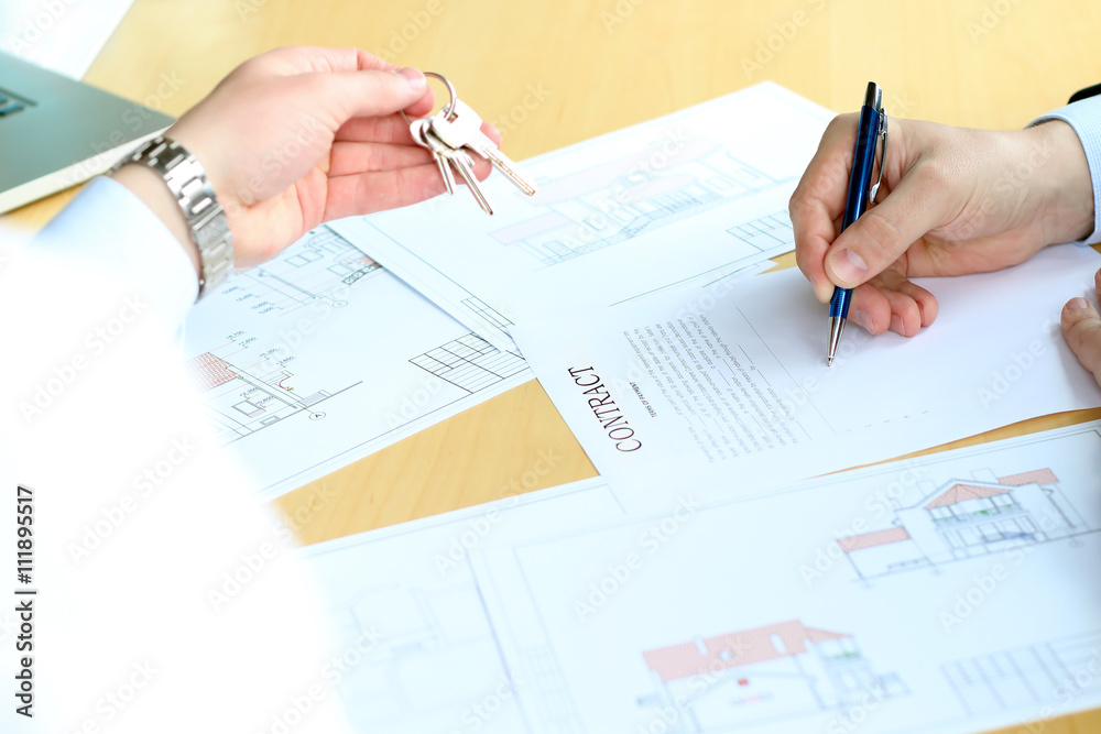 Estate agent giving keys to the business man during signing a co Estate agent giving keys to the business man during signing a co