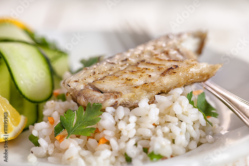 Healthy fish fillet on rice with zucchini