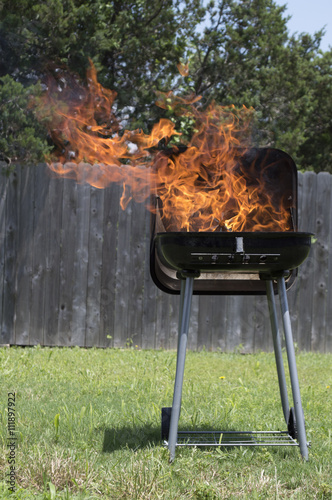 A small grill with a huge fire