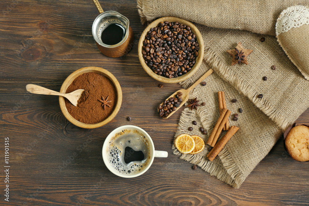Coffee with beans and spices on wooden table, top view