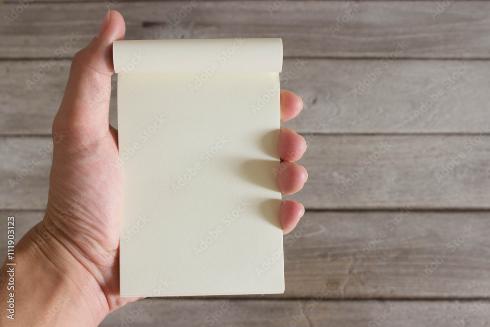 notebook in hand with wood background notebook in hand with wood background