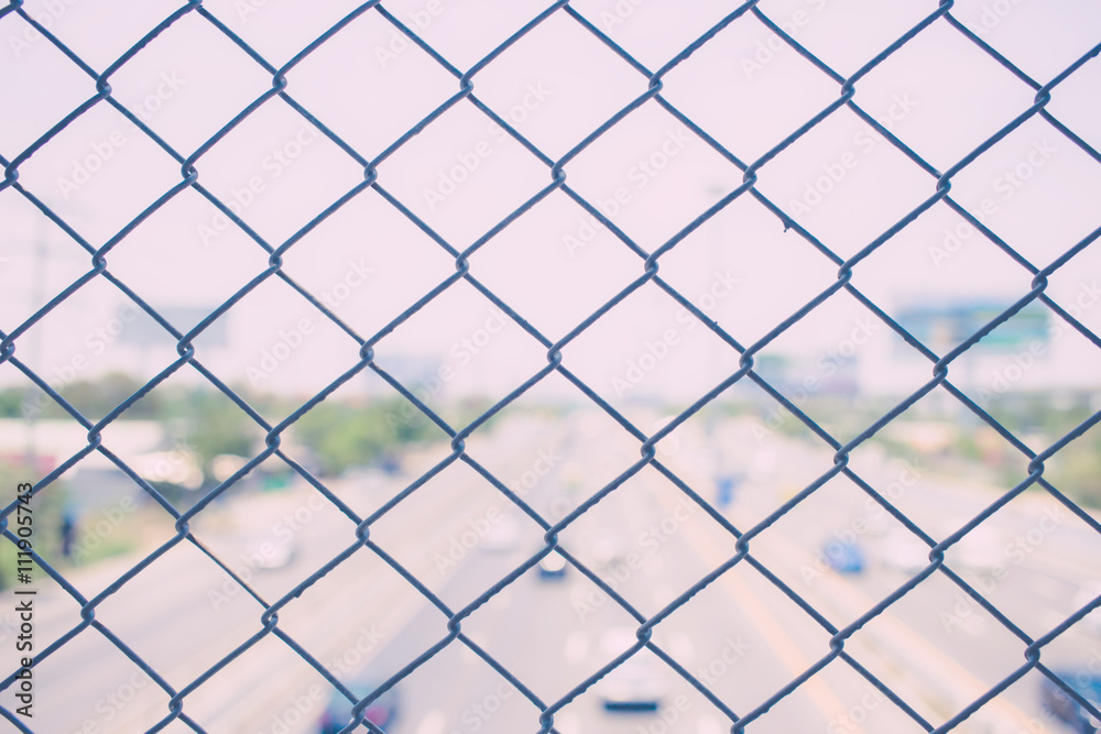 steel wire mesh (mesh fence) with city road highway out focus. vintage photo steel wire mesh (mesh fence) with city road highway out focus. vintage photo