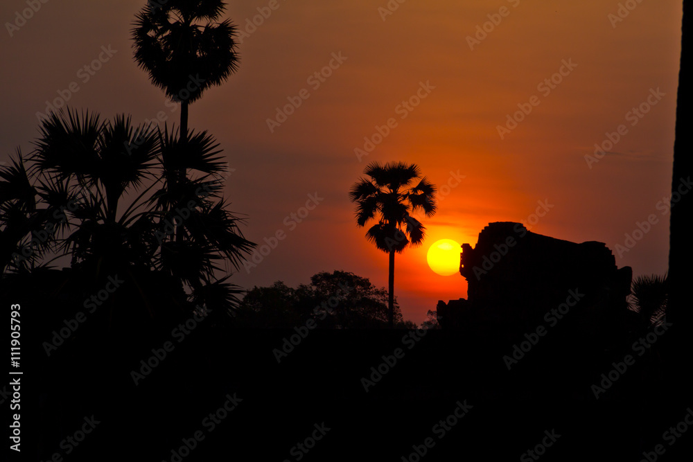 Sun rising behind ruins of Angkor Wat