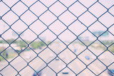 steel wire mesh (mesh fence) with city road highway out focus. vintage photo