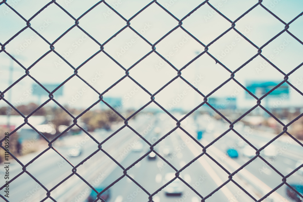 steel wire mesh (mesh fence) with city road highway out focus. vintage photo steel wire mesh (mesh fence) with city road highway out focus. vintage photo