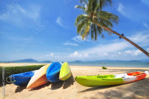Kayak boat with coconut palm trees and tropical beach background, happy summer holiday concept