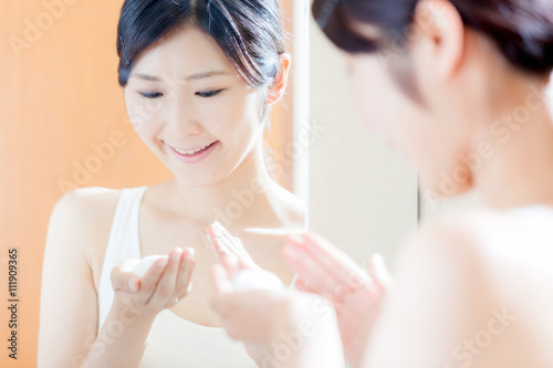 スキンケアをする女性、洗顔石鹸、鏡